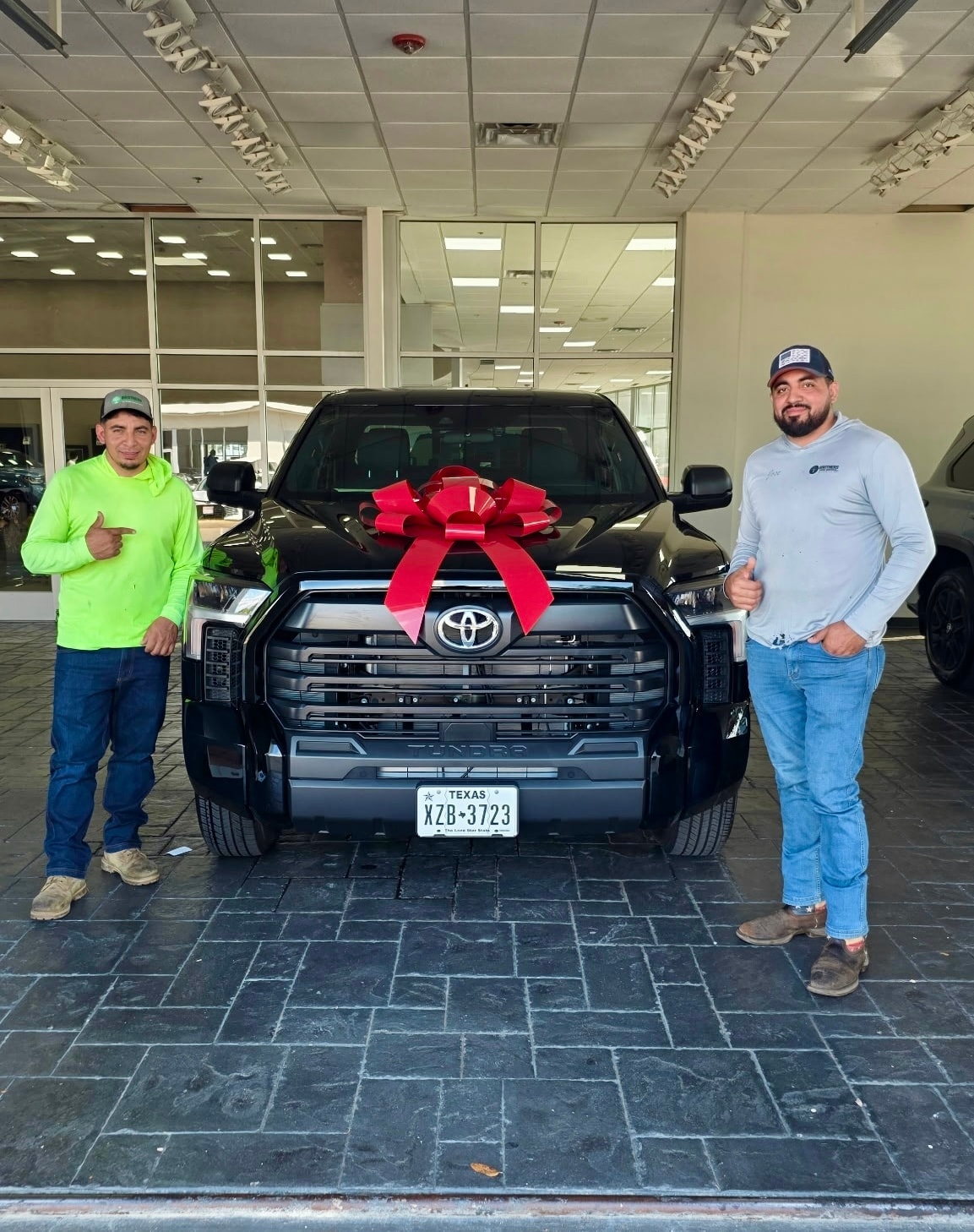 Happy customers with new black Toyota Tundra at Freeman Toyota dealership DFW
